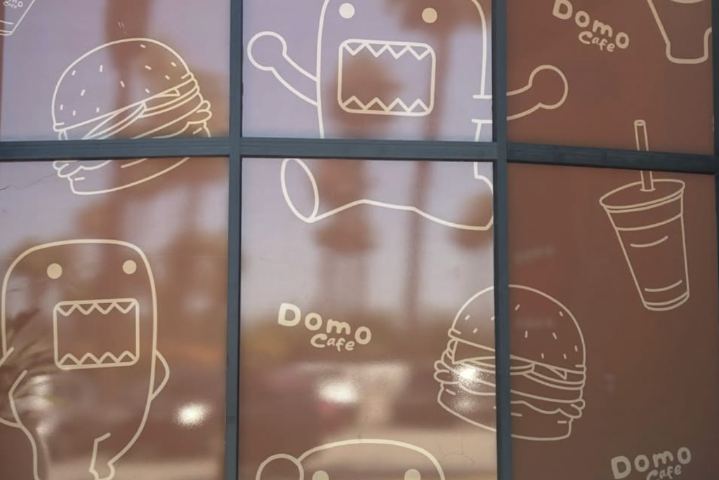 Domo Cafe window drawings of Domo, burgers, and drinks